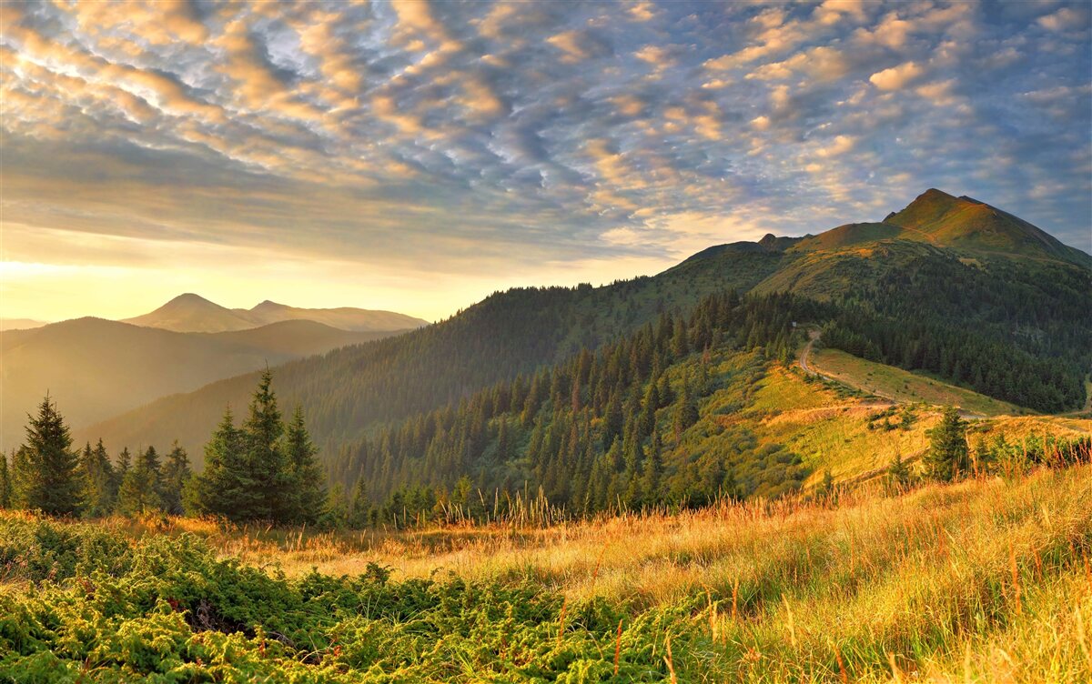 Fototapeta oblaky nad horami sú vymaľované teplými farbami západu slnka