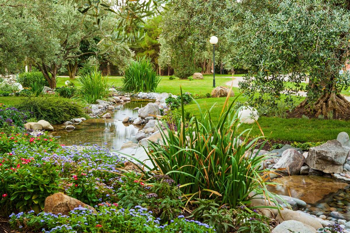 Fototapeta potok pretekajúci zelenou lúkou