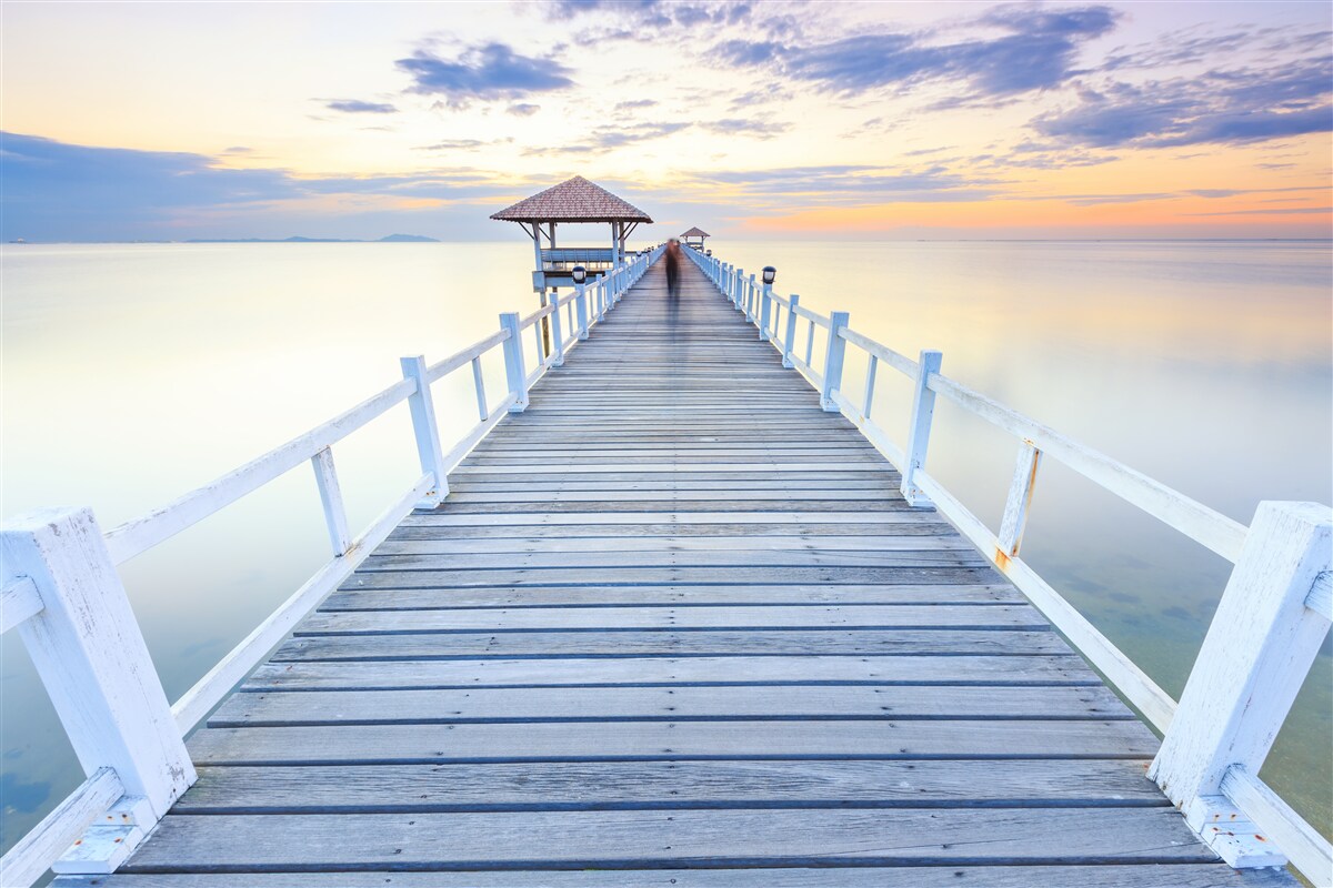 Fototapeta mólo s altánkom nad vodou za úsvitom, ktoré už videlo veľa